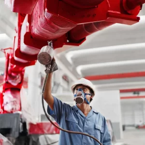 male-workers-spray-painting-a-crane-arm-red-in-fac-2022-03-04-01-48-52-utc